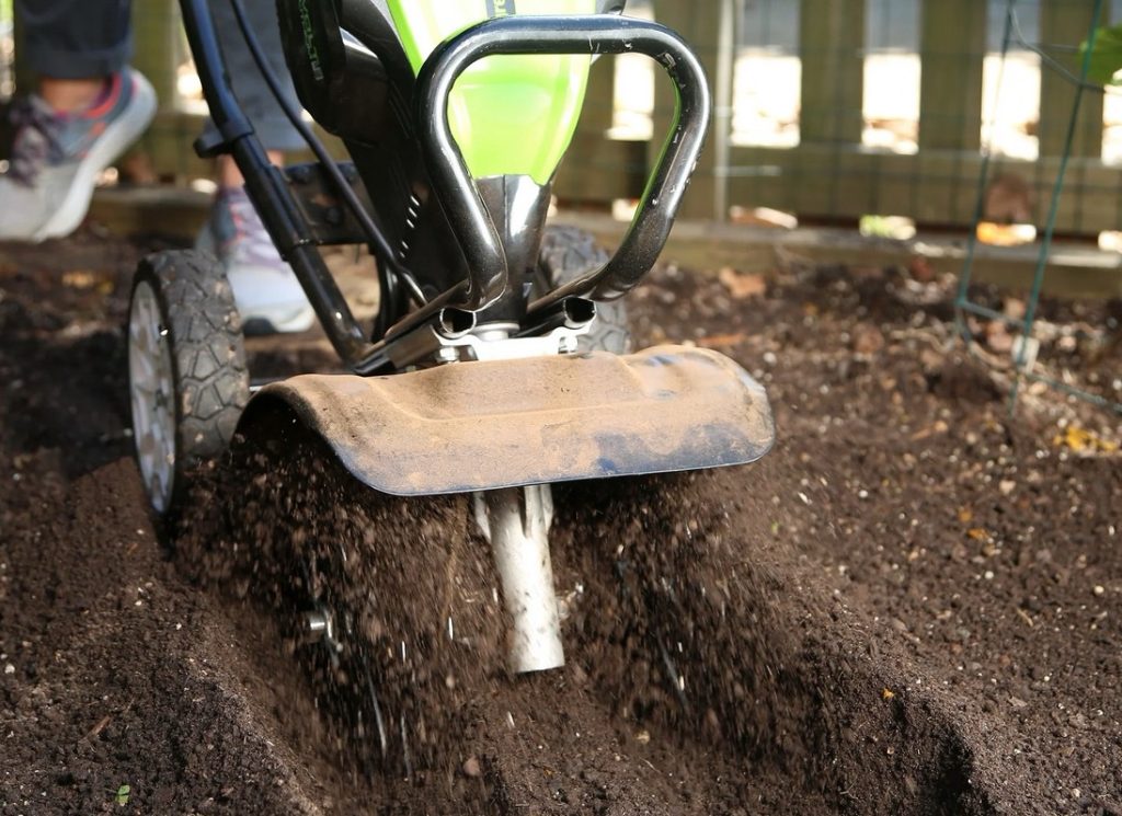 An electric cultivator being used to aerate the soil.